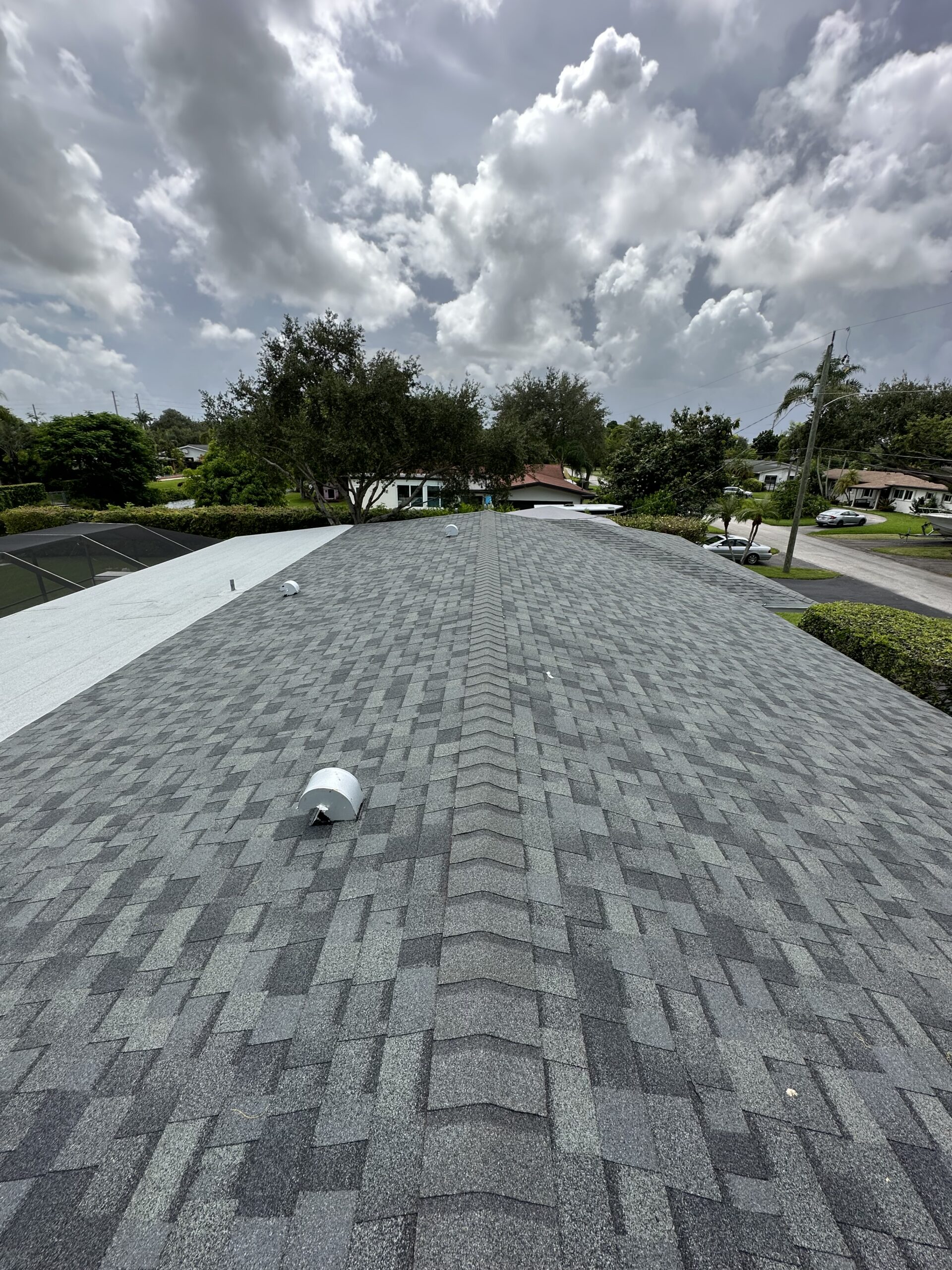 Technician from Rainbow Roofing Solutions inspecting a residential roof for repair and warranty in Plantation, Florida