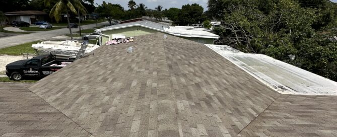 Roofer providing a free roof repair estimate in Coral Springs FL while inspecting shingles, flashing, and a roof leak area